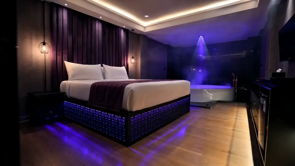 VIP suite with a king-size bed and a jacuzzi under violet light
